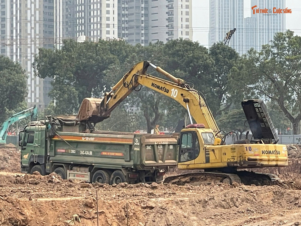 Máy móc hoạt động không ngừng để san gạt mặt bằng, đào lòng hồ. Cùng với đó là những chiếc xe tải liên tục vận chuyển đất, tạo nên bầu không khí khẩn trương trên công trường.