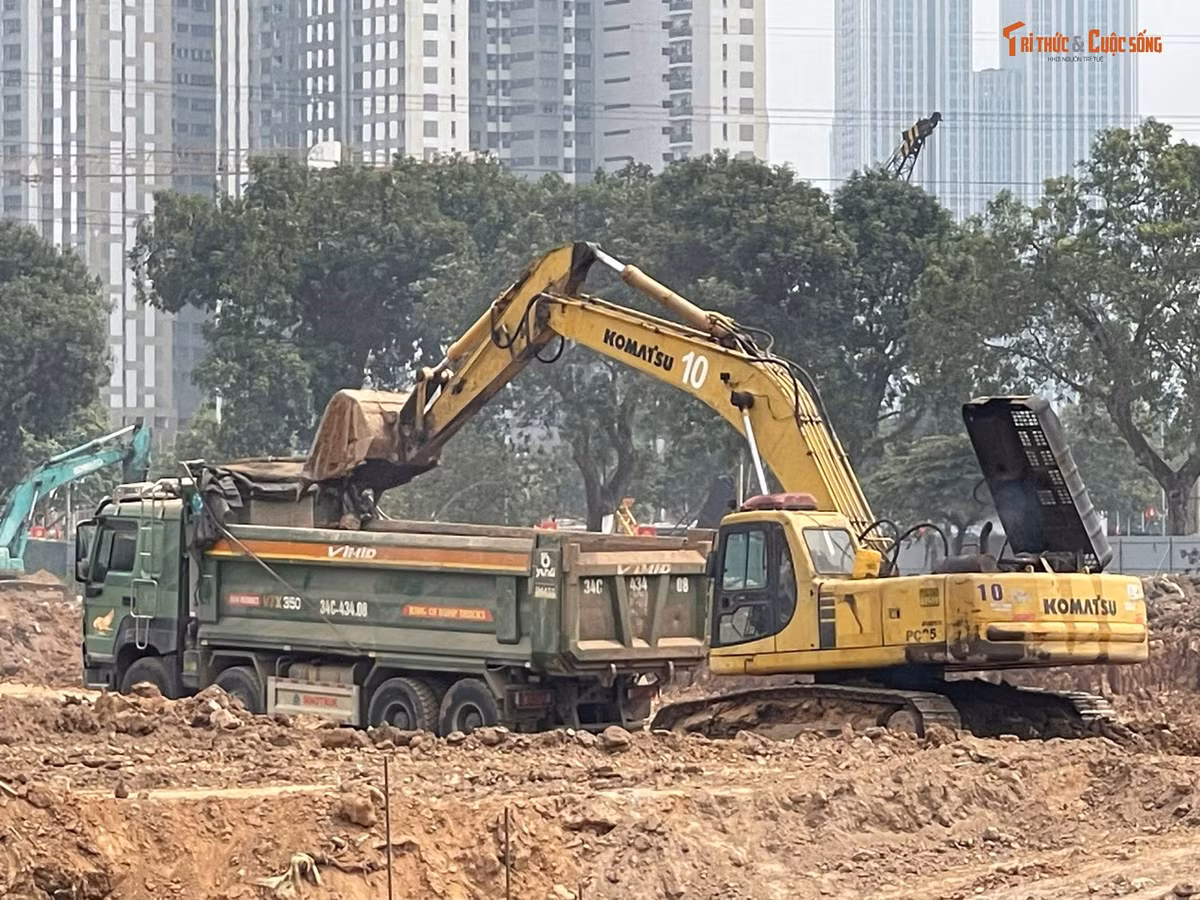 Máy móc hoạt động không ngừng để san gạt mặt bằng, đào lòng hồ. Cùng với đó là những chiếc xe tải liên tục vận chuyển đất, tạo nên bầu không khí khẩn trương trên công trường.