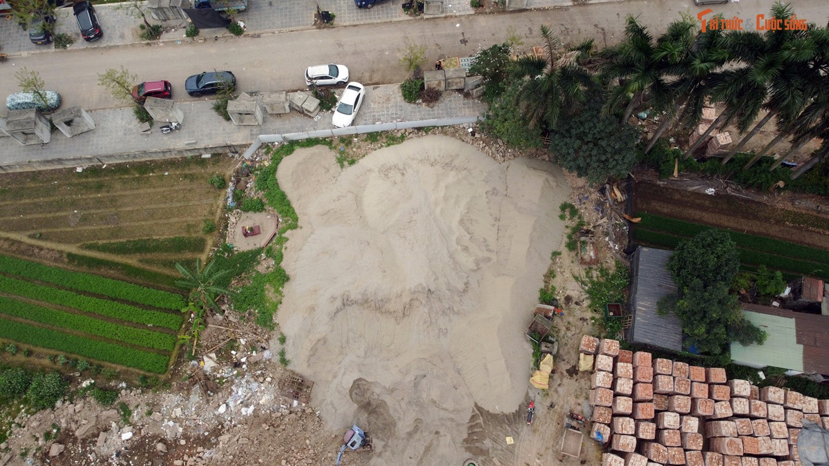 Các vật liệu như gạch, cát chất đống cao như “núi” bên trong bãi tập kết.