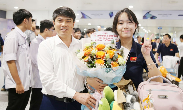 Ông Đoàn Xuân Thanh, Phó Giám đốc Sở Giáo dục và Đào tạo tặng hoa chúc mừng em Trương Xuân Thanh trở về từ cuộc thi IMO 2025. Ảnh: NVCC. truong-thanh-xuan.jpg