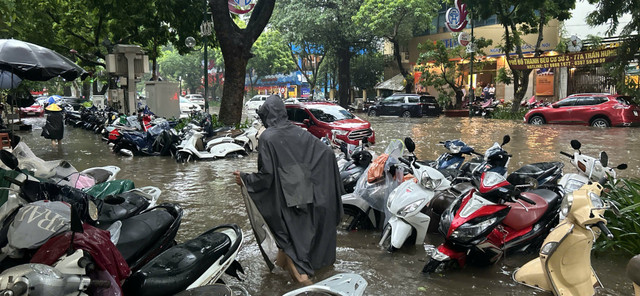 Xe để trên vỉa hè phố Trần Hưng Đạo cũng bị ngập quá nửa bánh. bao-3.jpg