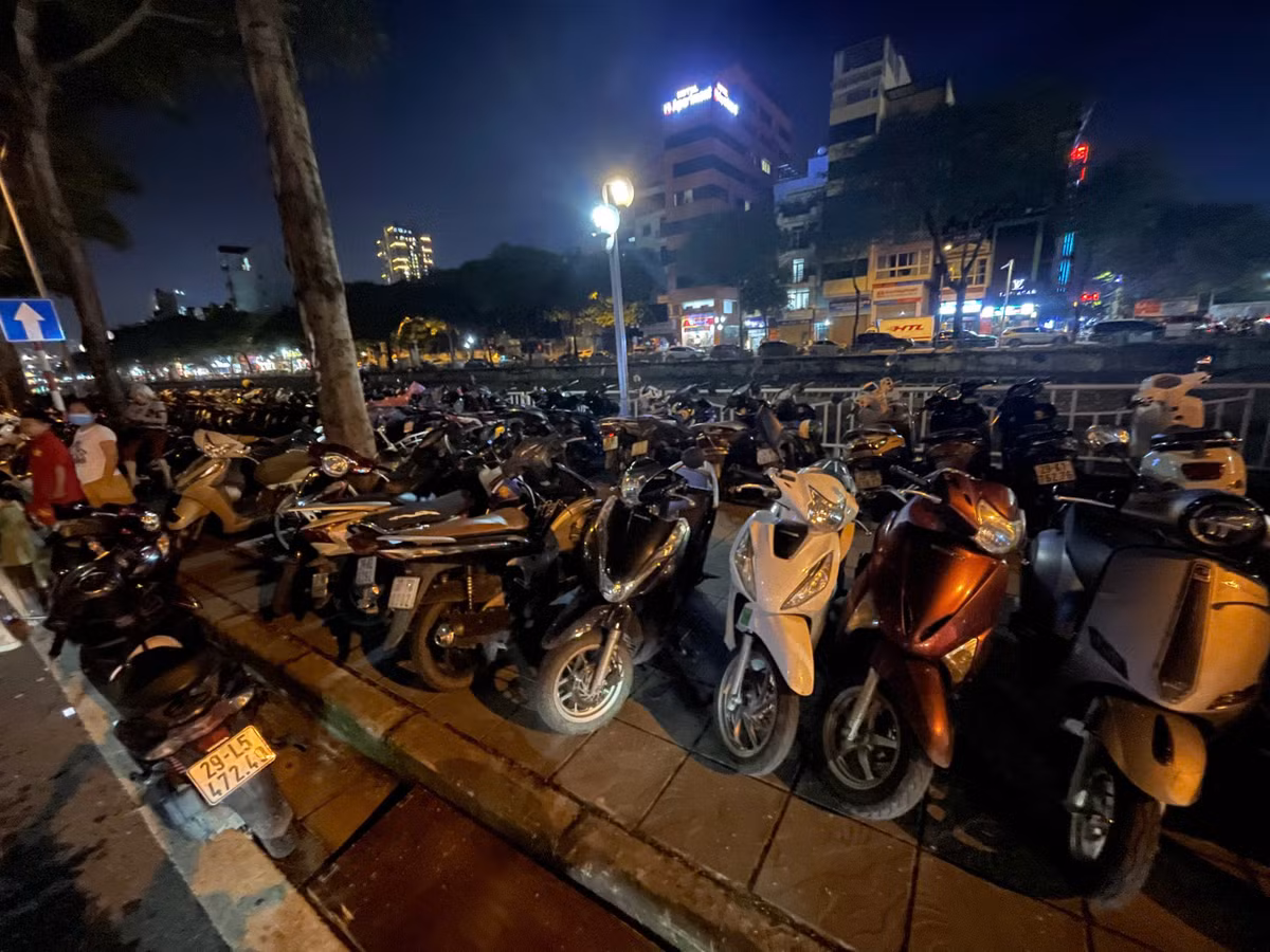 Hàng trăm chiếc xe máy được gửi xếp hàng dài tại đây. Ước tính hai bãi xe trái phép ở đoạn đường Bưởi thu lời của người dân trên dưới chục triệu đồng buổi tối 27/8.