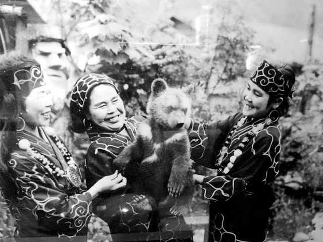 Theo quan niệm của người Ainu, Thần núi Chira-Mante-Kamui đã mượn thân xác con gấu đực để "đến thăm" mặt đất và con người. Họ coi gấu là vị thần tối cao, là thủ lĩnh của các vị thần và tổ tiên của nhân loại.