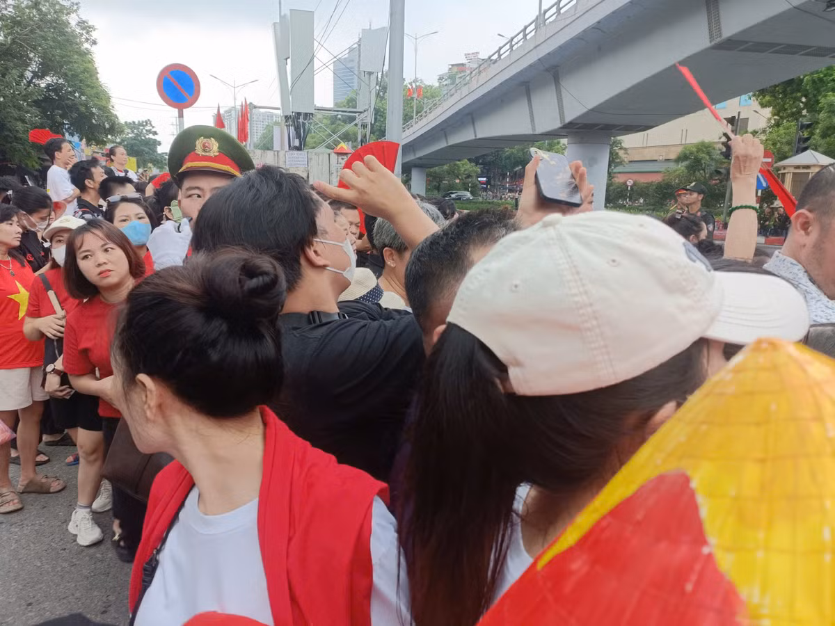 Ngay từ sáng, dù trời đổ mưa nặng hạt nhưng người dân vẫn đội mưa giữ chỗ chờ đợi tại khu vực ngã tư đường Thanh Niên - An Dương để xem các khối xe diễu hành.