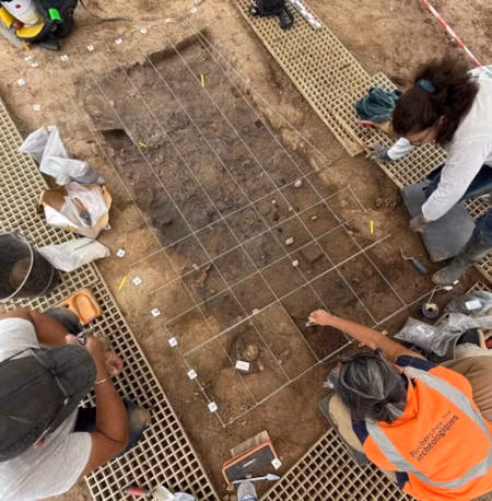 Ở một góc của ngôi mộ, các nhà khảo cổ tìm thấy một cốc gốm và một lọ thủy tinh trong suốt. Họ cũng phát hiện 10 đồng tiền bạc và đồng cùng với những tấm vàng nhỏ có thể đã được dùng để trang trí một chiếc ví hoặc hộp đựng tiền xu. Ảnh: Patrick Ernaux/Inrap.