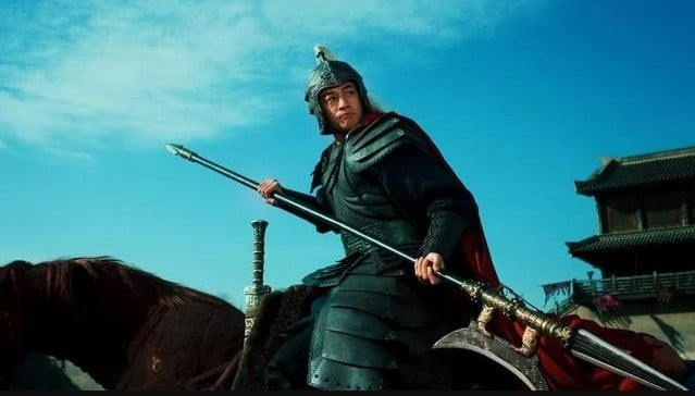 Lữ Bố đầu đội mũ trụ tử kim, mình khoác chiến bào đỏ rực, tay cầm Phương Thiên Họa Kích, cưỡi trên lưng ngựa Xích Thố hí vang trời, uy phong lẫm liệt đứng trước trận chiến. (Ảnh: Sohu)