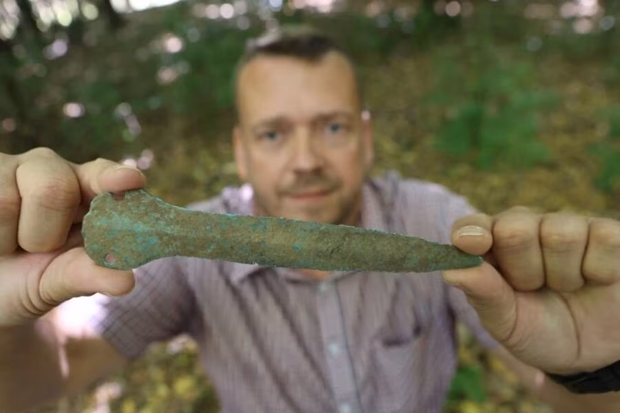 Khi cùng 2 con trai đi bộ qua khu rừng gần Gudersleben, Đức, Maik Böhner nhận thấy "có thứ gì đó màu xanh lục lóe lên từ mặt đất". Theo đó, ông Maik lại gần kiểm tra và phát hiện đó là một con dao găm. Nghi ngờ đây là cổ vật, ông đã báo cáo sự việc với với Văn phòng Bảo tồn Di tích và Khảo cổ học bang Thuringian tại Weimar. Ảnh: Matthias Bein/dpa.