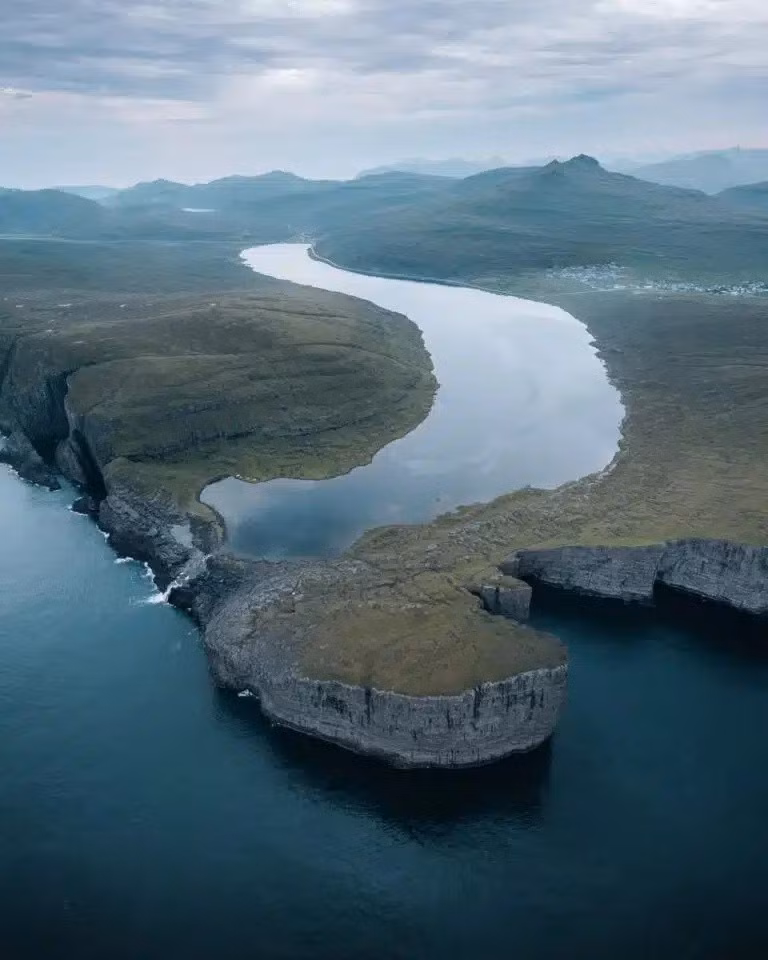 Thỉnh thoảng, nước trong hồ Sørvágsvatn quá đầy thì sẽ chảy xuống phía dưới trông giống như dòng thác đổ xuống biển. Ảnh: Scott Telford.