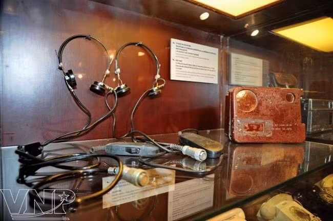 Được đánh giá là hiện đại nhất lúc bấy giờ, hầm chỉ huy tác chiến có hệ thống lọc bụi, chống nhiễu, hệ thống điều hòa và có khả năng chống được bom nguyên tử. Với diện tích 65 mét vuông, căn hầm chia làm 3 phòng: phòng giao ban tác chiến, phòng trực ban tác chiến và phòng thông hơi lọc độc lọc sạch. Ảnh:Tai nghe của tiểu đồ viên (dùng nghe và vẽ đường bay của địch để quân ta có phương án tác chiến hợp lý).