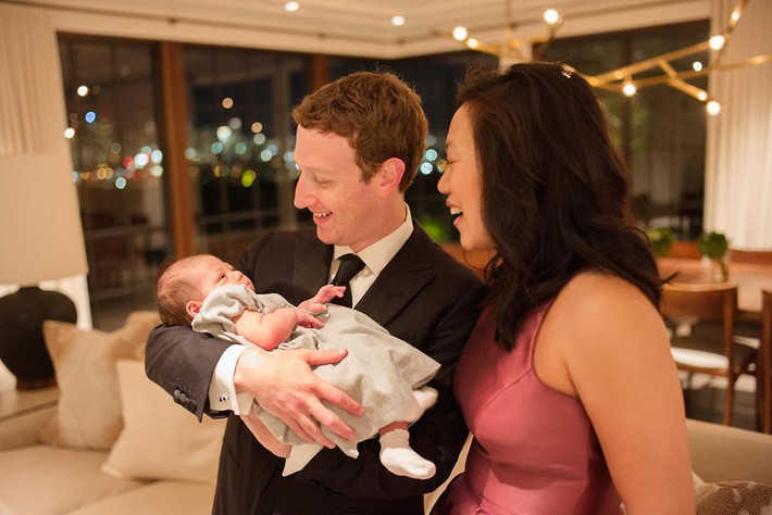 Gương mặt tràn ngập hạnh phúc của cả gia đình trẻ. Mark Zuckerberg mặc suit lịch lãm giúp vợ bế con gái trong tiệc mừng năm mới.