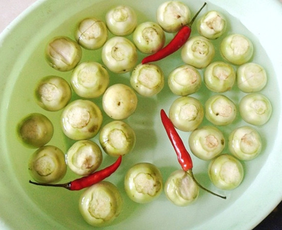 Hòa 2 thìa canh muối với 1 lít nước nóng rồi để cho nguội hẳn. Lấy ½ nước này tráng qua cà một lần cuối trước khi muối. Việc này giúp cho cà muối không bị nổi váng.