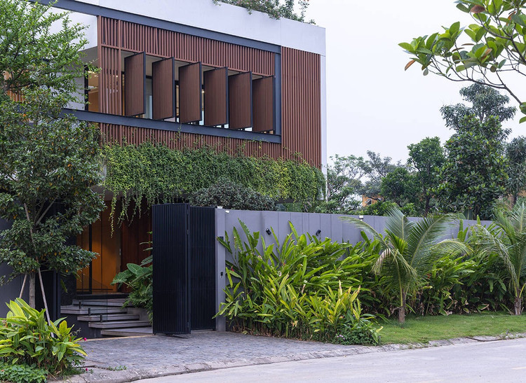 Khác với những căn biệt thự thường thấy tại địa phương - nơi nhà chiếm phần lớn đất, kiến trúc sư chọn lùi khối nhà về phía trong lô đất, nhường mặt ngoài làm sân vườn, hồ bơi và khoảng đệm. Ảnh: Triệu Chiến biet-thu5.jpg