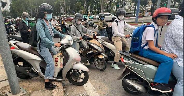 Nhiều người điều khiển xe máy leo lên lề đường bất chấp có thể bị xử phạt.