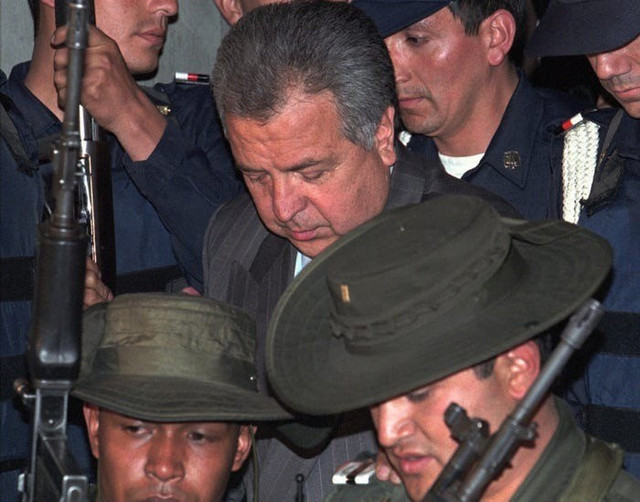 Gilberto Rodriguez Orejuela - thủ lĩnh băng đảng Cali Cartel - được cảnh sát Colombia hộ tống khi rời khỏi Văn phòng Công tố Liên bang ở Bogota, Colombia, ngày 6/2/1996. Ảnh: AP/Fernando Llano. 59b1c3a245e2381d008b534e.jpg