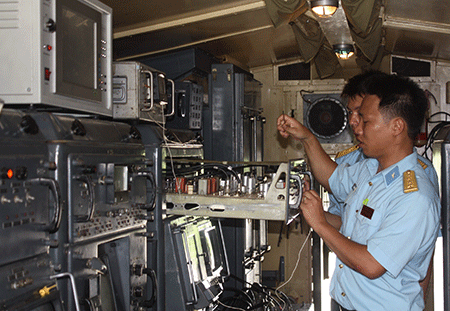 Đại úy Nguyễn Văn Đức, Đại đội trưởng Đại đội 1, Tiểu đoàn 62 (Trung đoàn 236, Sư đoàn 361) cùng đồng đội tháo linh kiện điện tử, thực hiện công tác bảo dưỡng định kỳ trong ca-bin đài điều khiển.