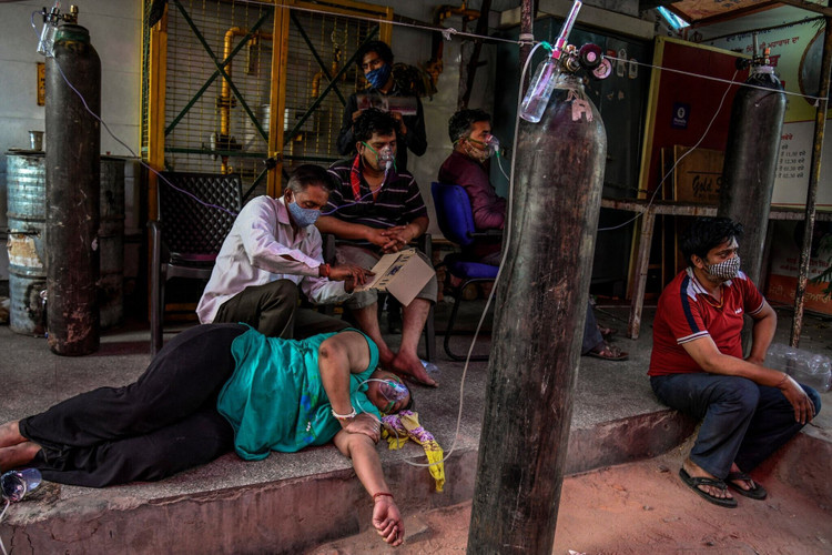 Bệnh nhân mắc COVID-19 thở oxy bên ngoài một ngôi đền ở New Delhi. (Ảnh: New York Times) Ấn Độ: Tỷ lệ mắc COVID-19 cao không tưởng, dân ngồi nhà 'chờ' dịch tới - 2