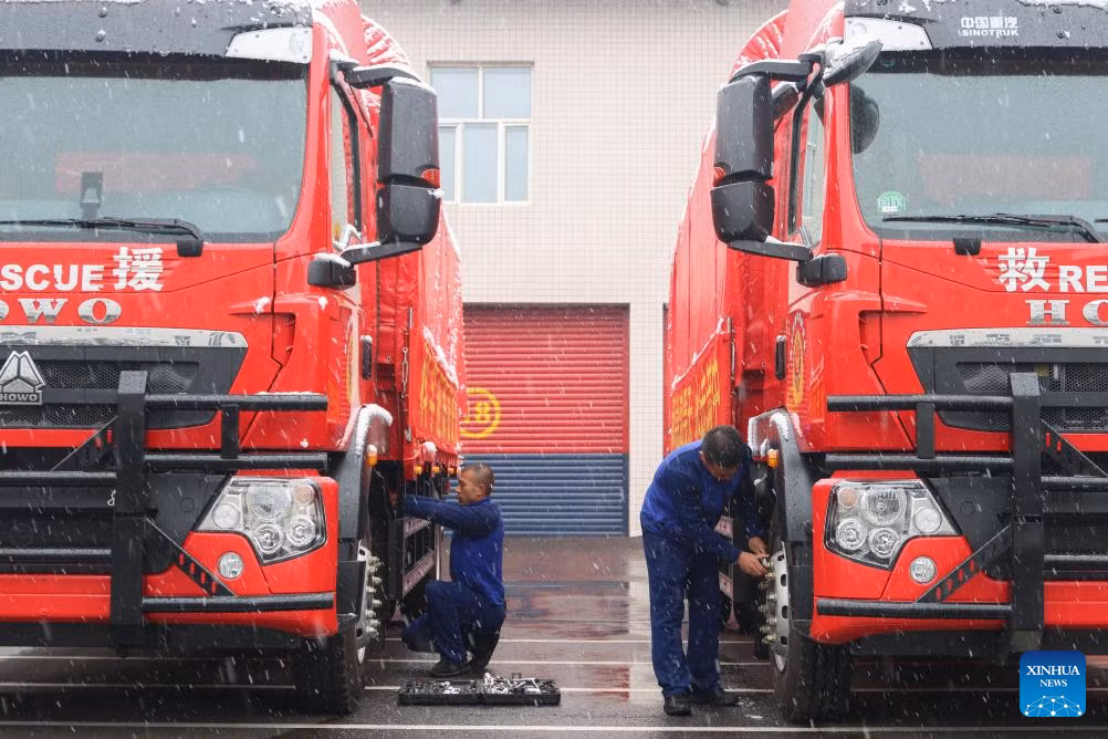 Lính cứu hỏa kiểm tra tình trạng của các xe cứu hộ giữa trời tuyết rơi ở Cáp Nhĩ Tân.