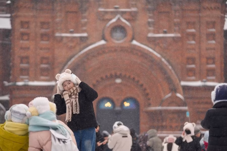 Cô gái chụp ảnh lưu niệm tại một quảng trường ở Cáp Nhĩ Tân ngày 23/12/2025. Ảnh: Xinhua.