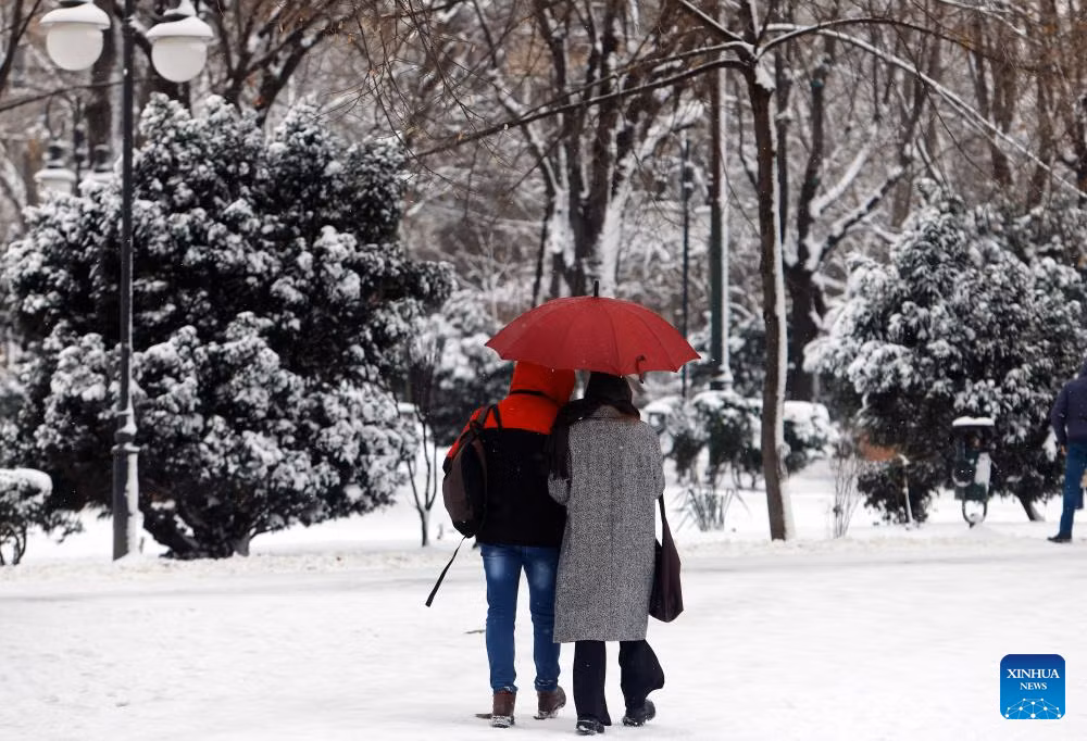 Mọi người đi dạo trong một công viên ở Bucharest giữa mùa đông lạnh giá.