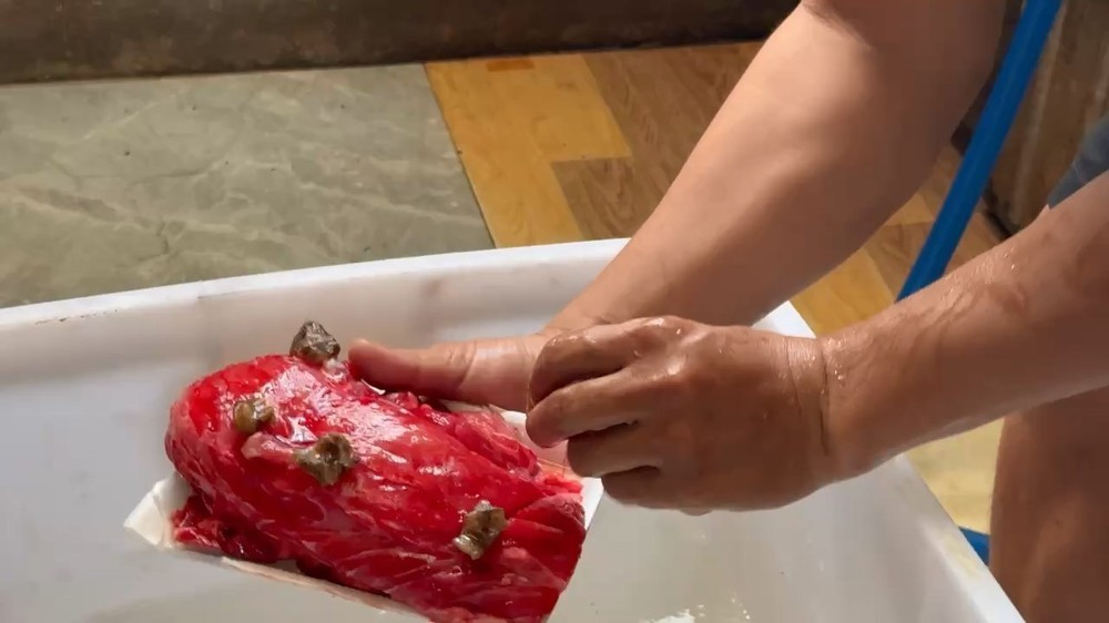 Da đà điểu được cắt thành lát rồi rải đều lên thịt lợn. Ảnh: CA