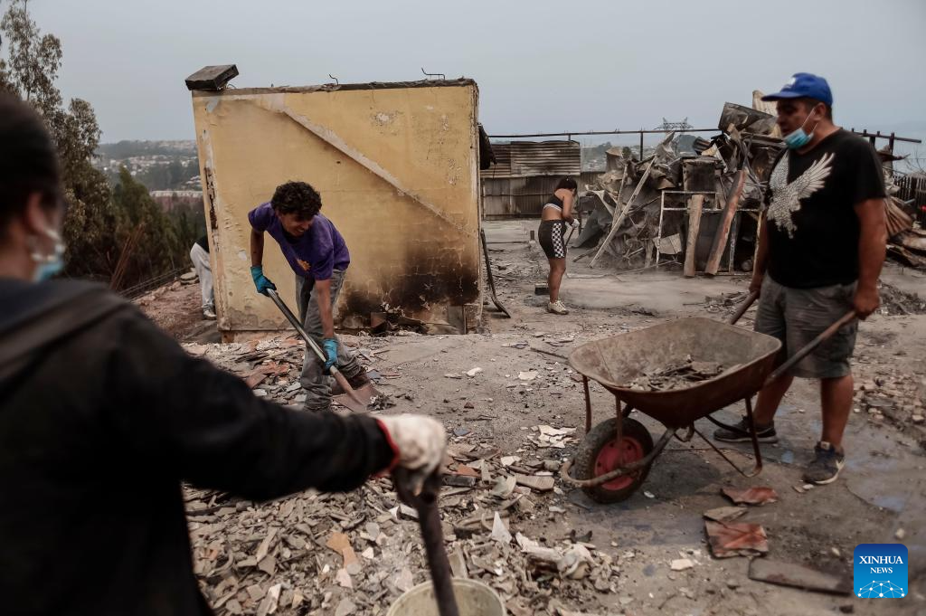 "325 ngôi nhà đã bị phá hủy hoàn toàn do cháy rừng trong khi 1.140 ngôi nhà khác bị hư hại", quan chức Chile thông tin. Ảnh: Người dân dọn dẹp khu vực bị ảnh hưởng bởi đám cháy ở Penco, vùng Biobio, Chile, ngày 19/1/2026. Ảnh: Xinhua.