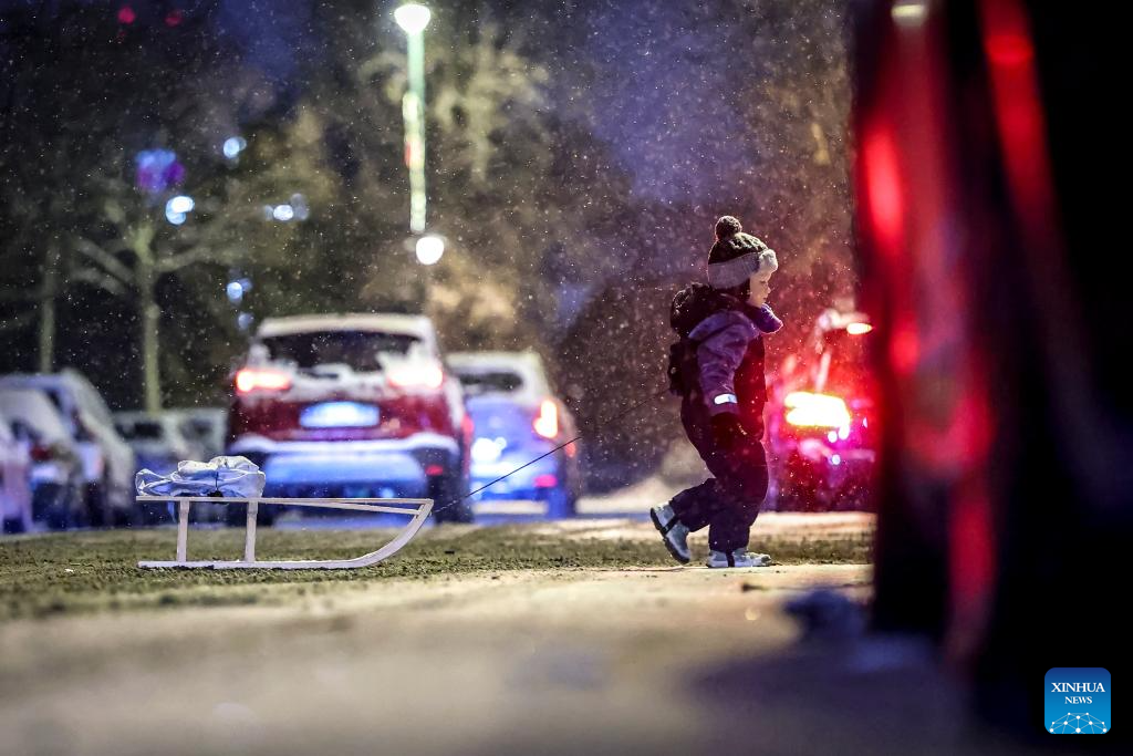 Một em nhỏ đi dưới trời tuyết rơi ở thủ đô Budapest. Ảnh: Xinhua.