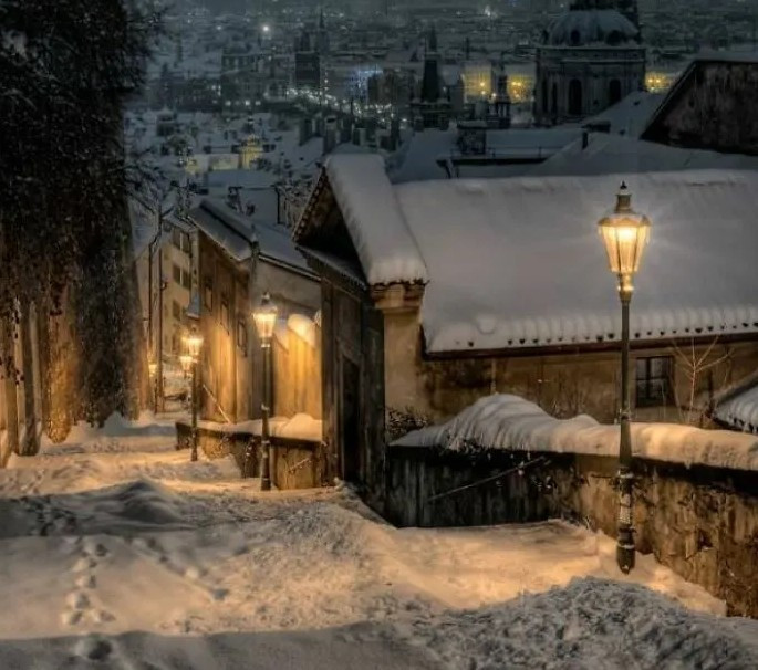 Một đêm mùa đông lạnh giá yên tĩnh ở Prague, Séc. Tuyết phủ trắng trên những mái nhà và con đường.