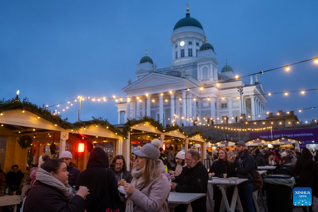 Mọi người thưởng thức đồ ăn và thức uống tại khu chợ Giáng sinh Helsinki ngày 5/12/2025.