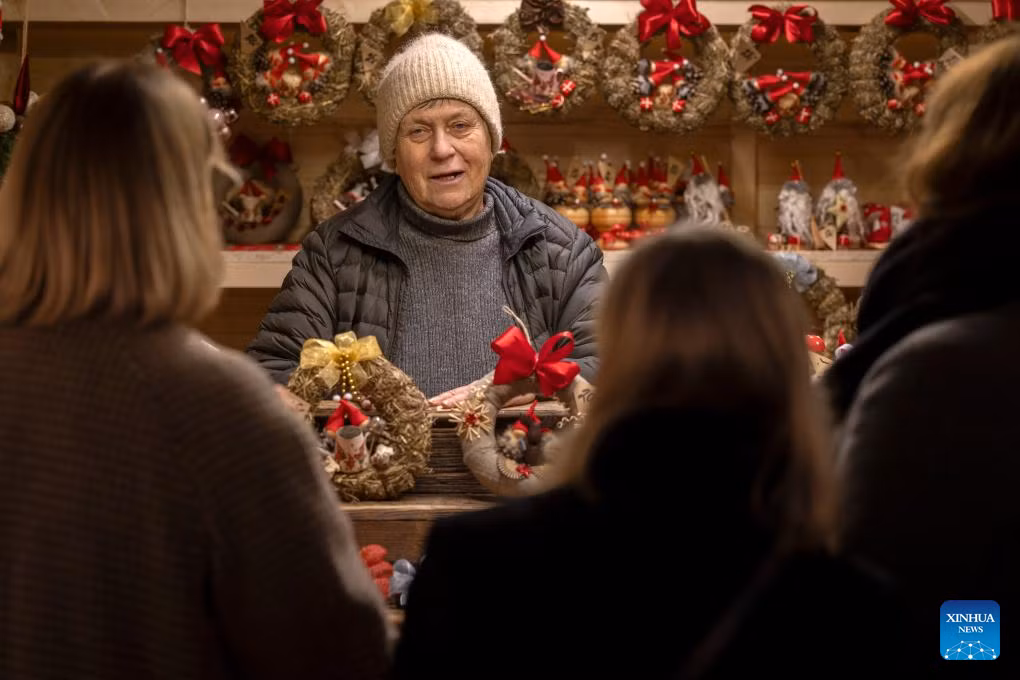 Một người bán hàng giới thiệu sản phẩm cho khách tham quan tại một gian hàng thủ công mỹ nghệ ở chợ Giáng sinh Helsinki ngày 5/12/2025.