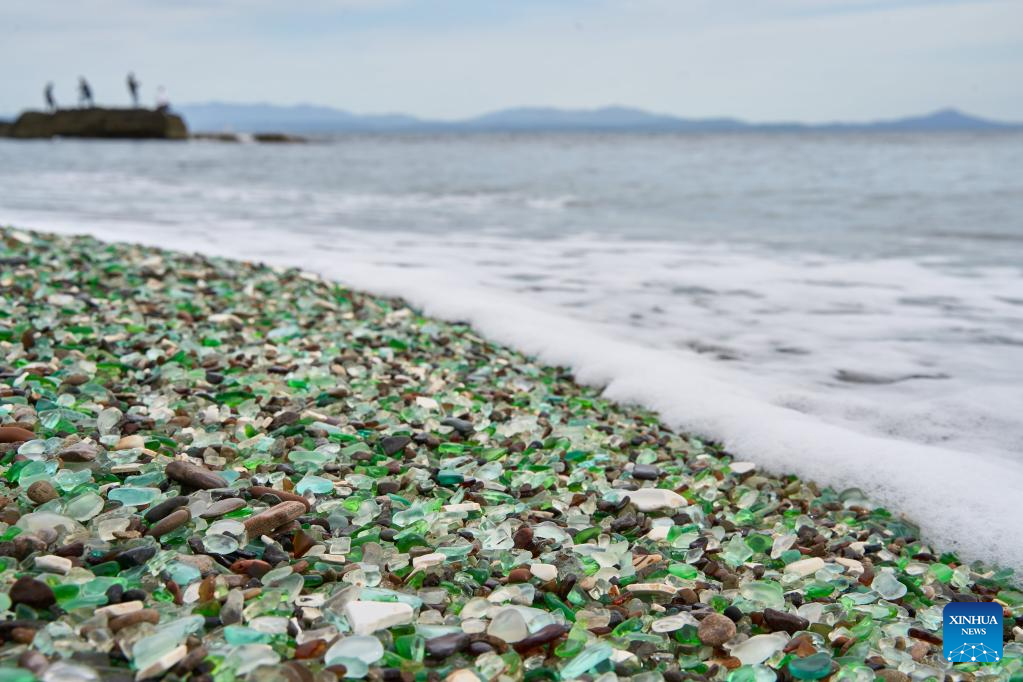 Tuy nhiên, sau nhiều thập kỷ bị sóng biển bào mòn, những mảnh thủy tinh đã được mài nhẵn thành những viên đá cuội đầy màu sắc, tạo nên khung cảnh bờ biển sống động, thu hút đông đảo du khách. Ảnh: Xinhua News.