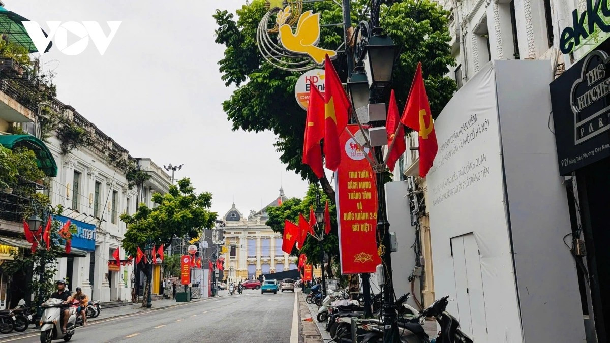 Dưới ánh nắng vàng dịu nhẹ của mùa thu, những là cờ như rực rỡ hơn, soi chiếu lên dãy nhà cổ kính mang đậm dấu ấn Hà Nội, khiến nơi đây vừa trang nghiêm, vừa rộn ràng hơi thở của ngày hội lớn đang đến gần.