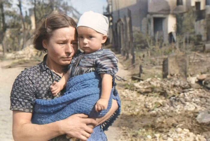 Một phụ nữ Ba Lan bế đứa con nhỏ của mình trên con phố Warsaw đã bị phá hủy bởi các cuộc không kích của Đức Quốc xã vào tháng 9/1939.