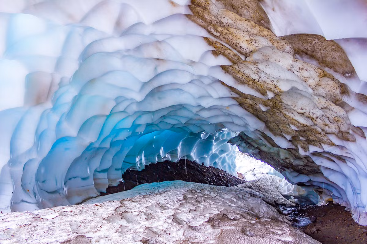 Hang băng của núi lửa Mutnovsky được tạo ra bởi dòng nước nóng chảy ngầm và nhiệt từ núi lửa kết hợp với sông băng. Sự tương tác giữa băng và nhiệt đã tạo ra những hang động với trần băng trong suốt, phản chiếu ánh sáng mặt trời và tạo nên hiệu ứng màu sắc huyền ảo. Ảnh: GI.