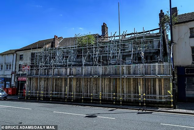 Một quán rượu cũ bên cạnh bưu điện bị đóng cửa và bỏ hoang với giàn giáo phía trên.