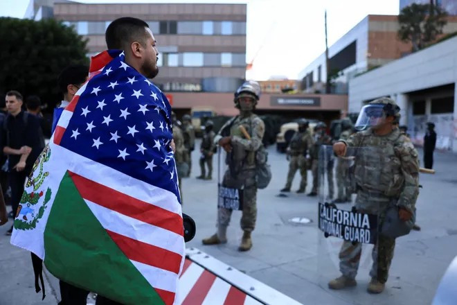 Một người biểu tình đứng trước các thành viên của lực lượng Vệ binh Quốc gia California gần Tòa nhà Liên bang Edward R. Roybal tại Los Angeles ngày 11/6/2025.