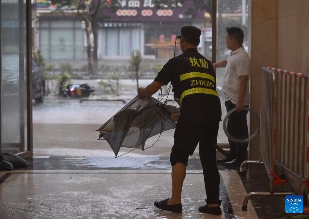 Một nhân viên sửa chiếc ô bị gió làm hỏng tại một khách sạn ở thành phố Dương Giang. Ảnh: THX.