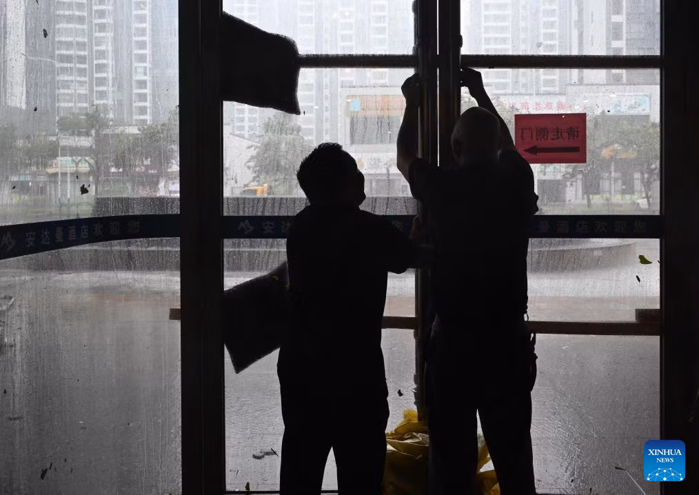 Các nhân viên gia cố cửa kính tại một khách sạn ở thành phố Dương Giang, tỉnh Quảng Đông, miền nam Trung Quốc, ngày 24/9. Ảnh: THX.