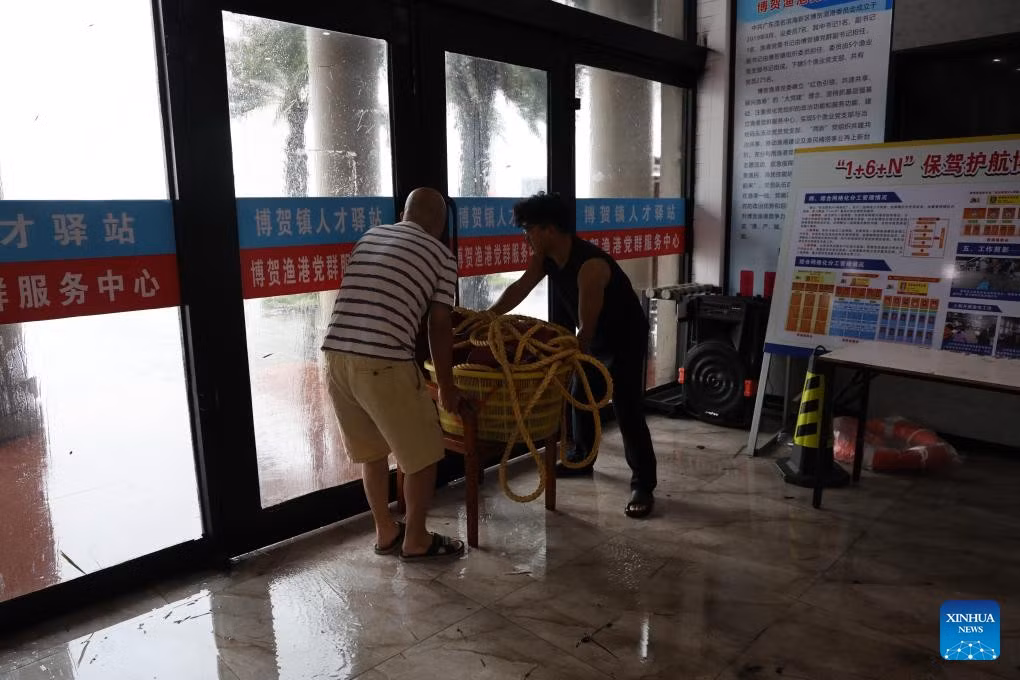 Người dân chặn cửa khi gió mạnh tại một cảng cá ở thành phố Mậu Danh ngày 5/10. Ảnh: THX.