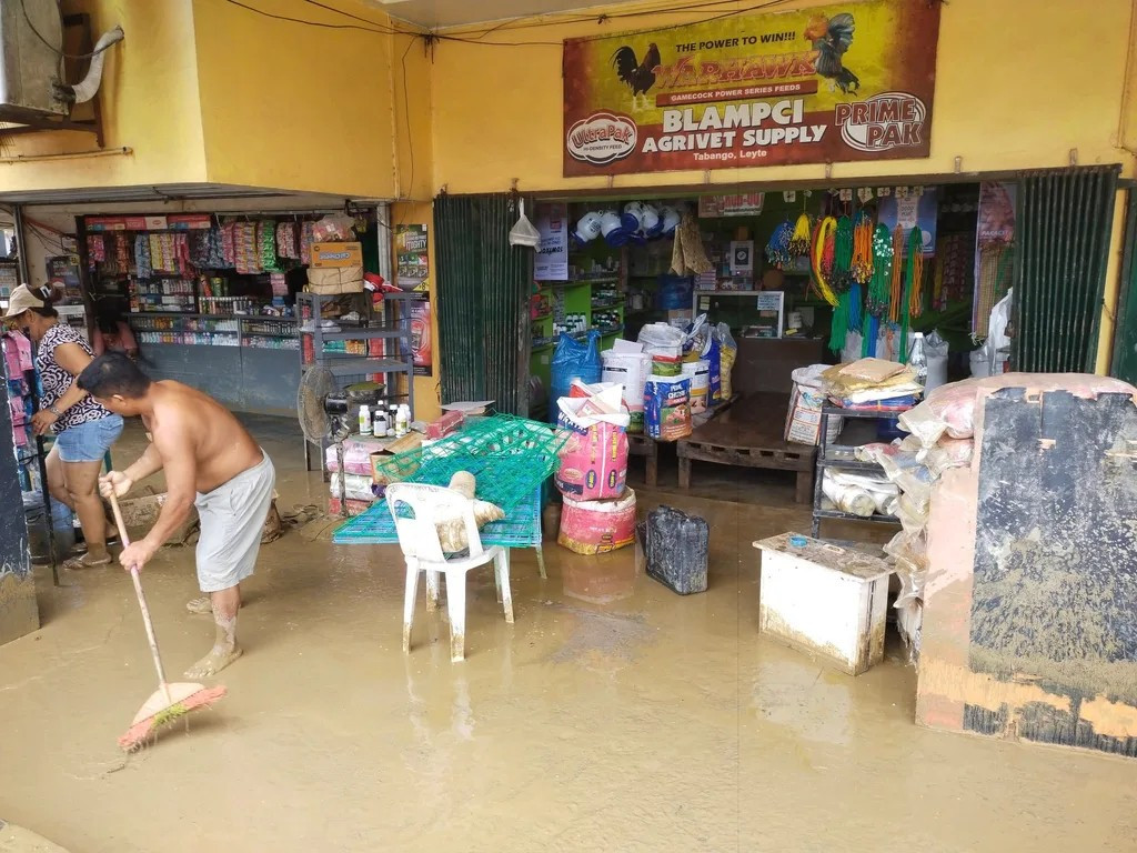 Người dân ở Tabango, Leyte, dọn dẹp bùn đất sau khi bão Bualoi đổ bộ vào khu vực này.