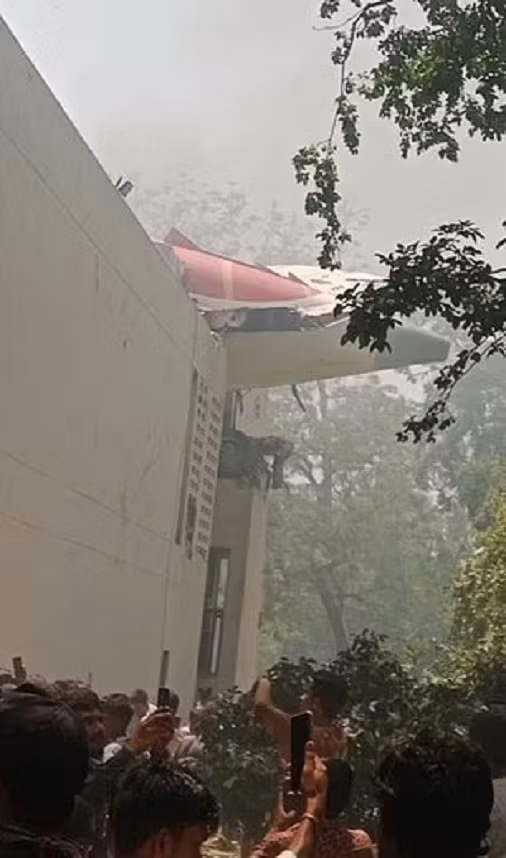 Một phần máy bay nhô ra khỏi một tòa nhà sau khi rơi xuống. Ảnh: DM.