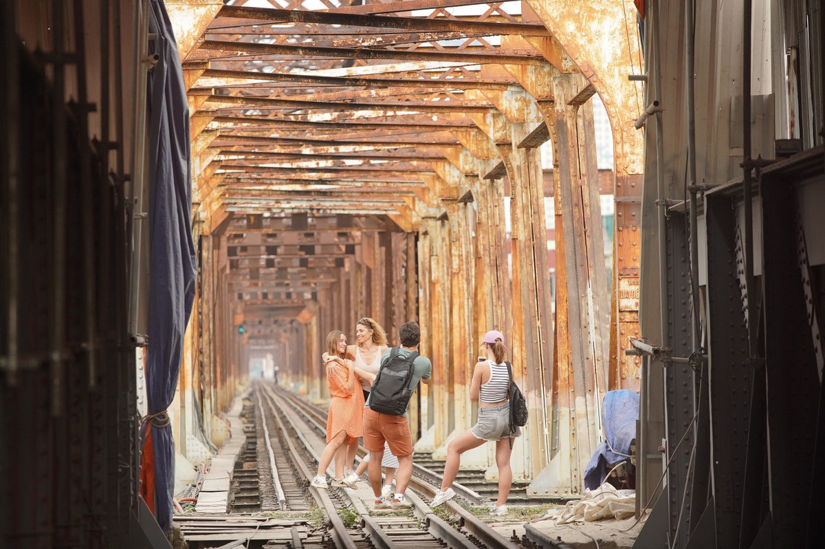 Khách tây thích thú chụp ảnh đường ray tàu hỏa trên cầu Long Biên.