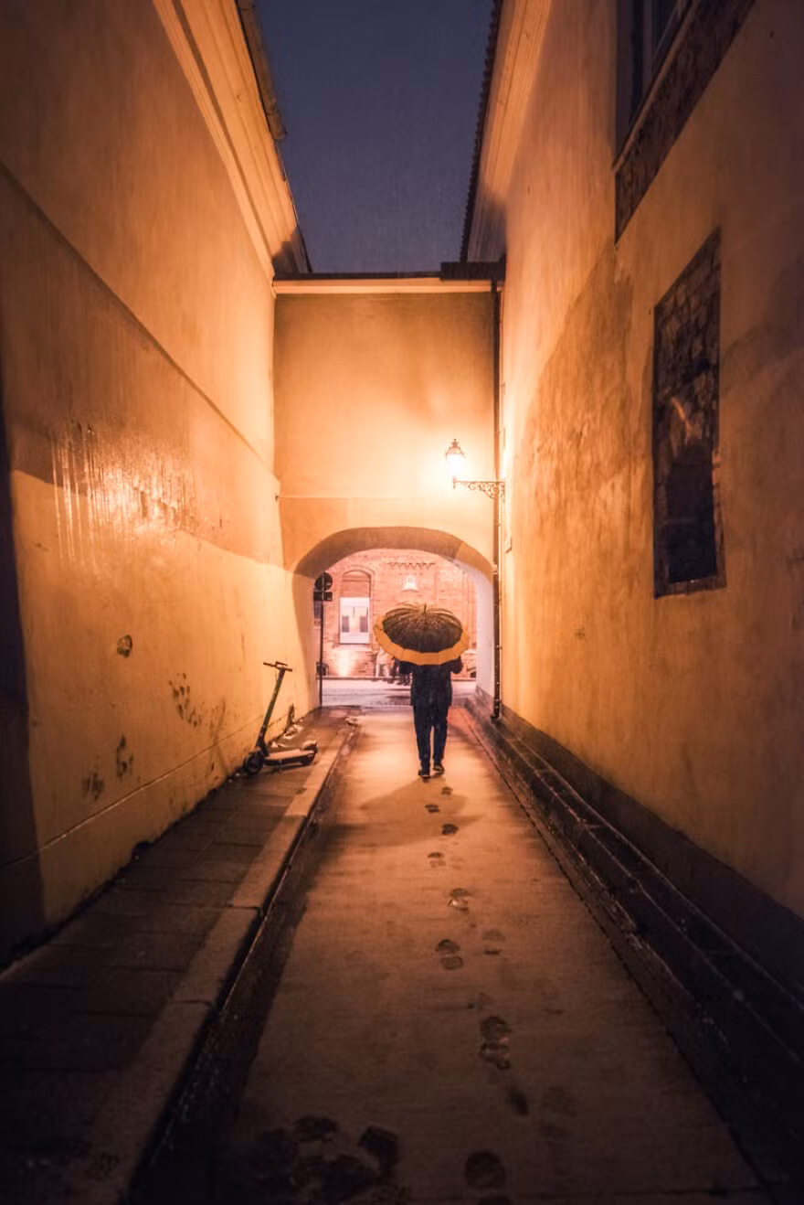 Một người che ô đi bộ trên phố Skapo.