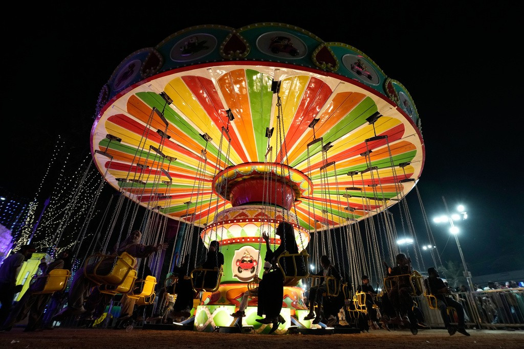 Mọi người thích thú chơi đu quay tại triển lãm công nghiệp ở Hyderabad ngày 28/1.