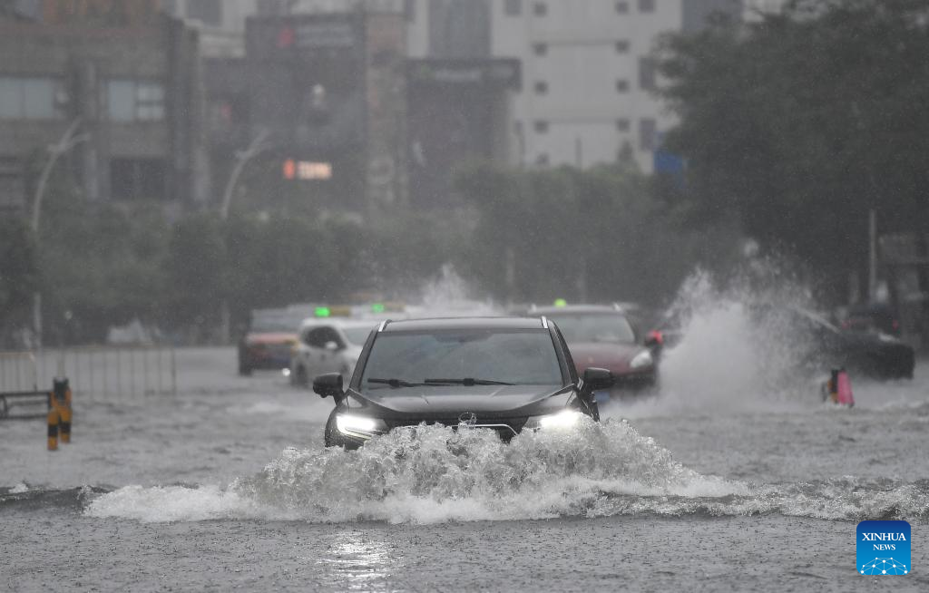 Xe cộ di chuyển qua con đường ngập lụt ở Hải Khẩu, tỉnh Hải Nam, miền nam Trung Quốc, ngày 20/7.