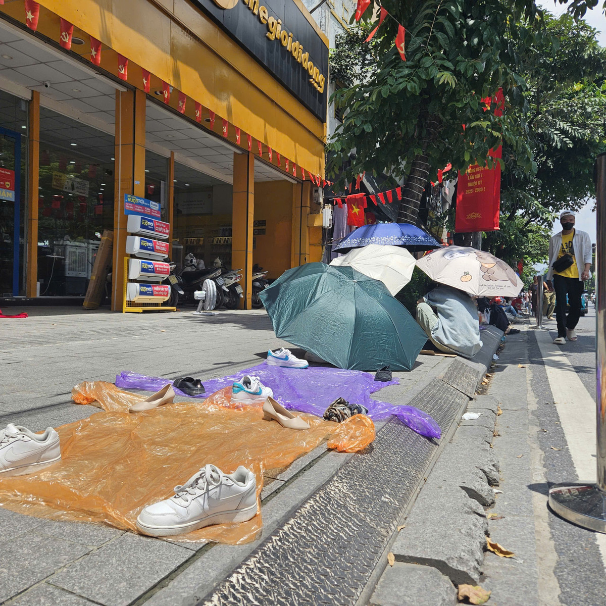 Nhiều người dân tại địa phương mang ghế, dép, trải áo mưa để "nhận chỗ".