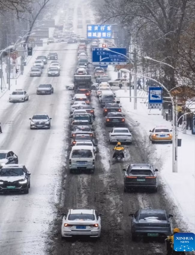 Những chiếc xe lưu thông trên đường phố ở Trường Xuân, tỉnh Cát Lâm, trong một ngày tuyết rơi vào mùa đông.