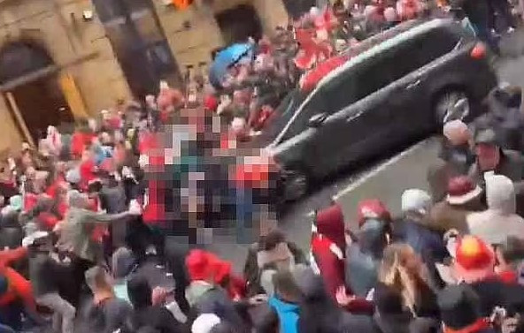 Chiếc xe chậm dần rồi dừng lại. Nhiều người tức giận đập phá xe, ném chai lọ trong khi một số người khác mắc kẹt dưới bánh xe. Ảnh: DM.