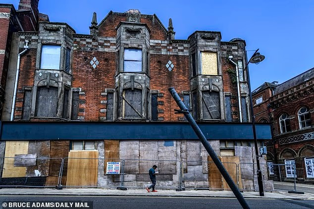 Các căn hộ ở tầng trên của tòa nhà này đang xuống cấp trong khi những cửa hàng phía dưới đều đã đóng kín.