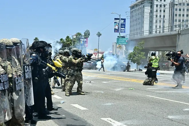 Binh lính Vệ binh Quốc gia và cảnh sát Bộ An ninh Nội địa Mỹ (DHS) đụng độ với người biểu tình bên ngoài Trung tâm giam giữ Metropolitan ở trung tâm thành phố Los Angeles, California, vào ngày 8/6.