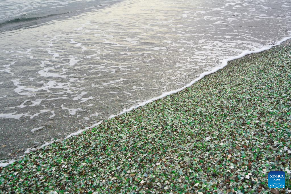 Theo Tân Hoa Xã, bãi biển thủy tinh này từng là một bãi phế liệu gồm hàng triệu mảnh vỡ chai lọ thủy tinh và đồ sứ bị vứt bỏ,... Ảnh: Xinhua News.